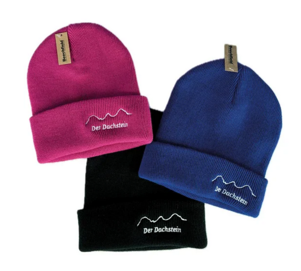Drei Kindermützen in Pink, Blau und Schwarz mit gesticktem Dachstein-Schriftzug und Logo | © Planai-Hochwurzen-Bahnen Gesellschaft m.b.H.