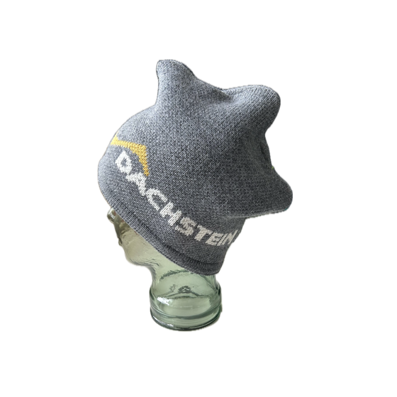 Grey knitted beanie with yellow zigzag and white Dachstein logo worn sideways on glass head | © Planai-Hochwurzen-Bahnen Gesellschaft m.b.H.