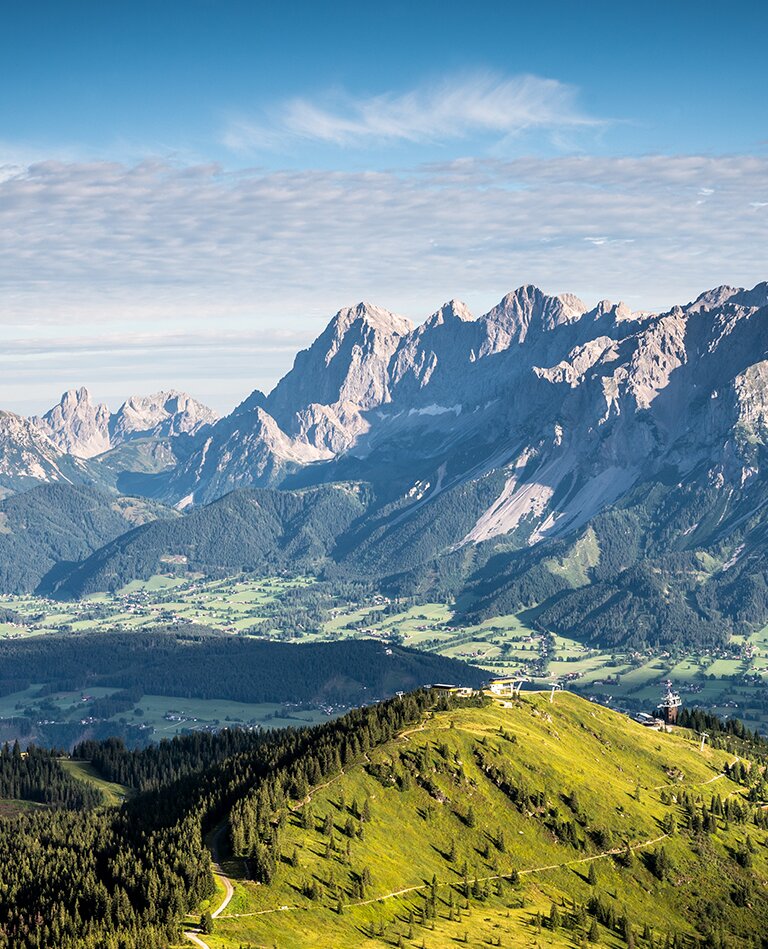 Panoramablick vom Krahbergzinken über grüne Bergrücken, Wälder und Täler bis zur eindrucksvollen Dachstein-Südwand | © Planai-Hochwurzen-Bahnen Gesellschaft m.b.H.